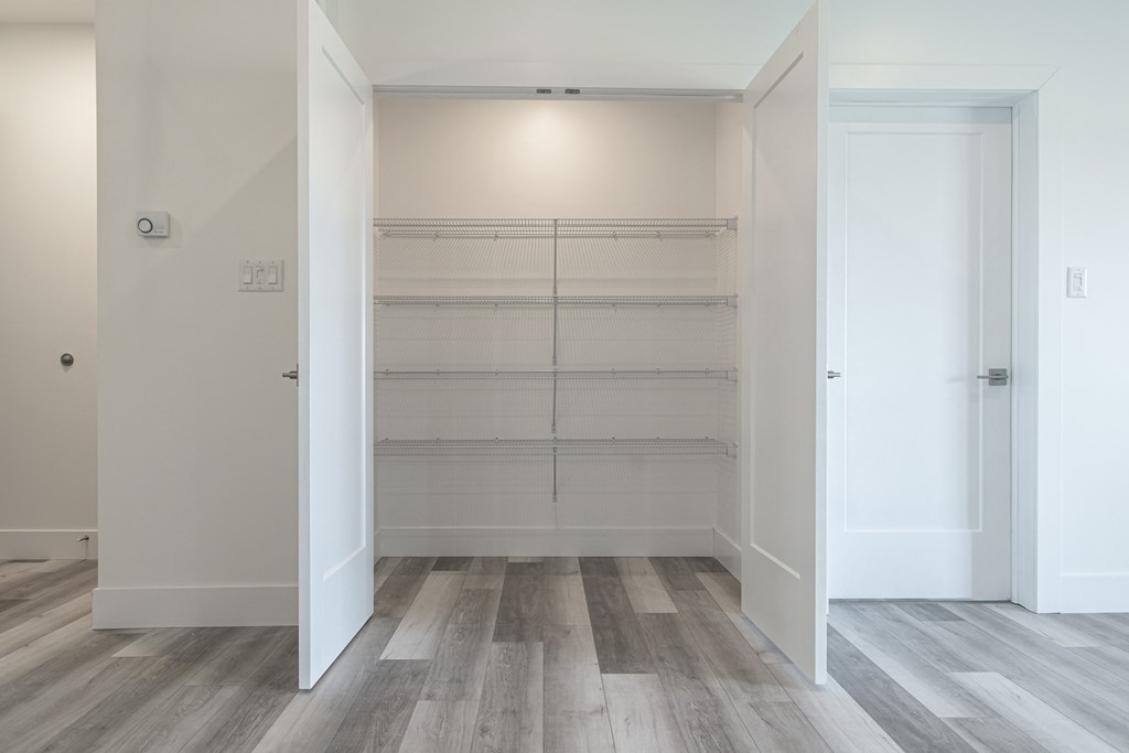 an empty room with white walls and wood flooring