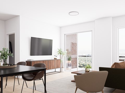 A modern living room with a flat screen TV, a black table and brown chairs.