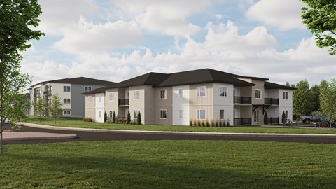 A modern apartment complex with a grassy front yard.