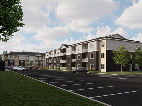 A modern apartment complex with a parking lot in front.