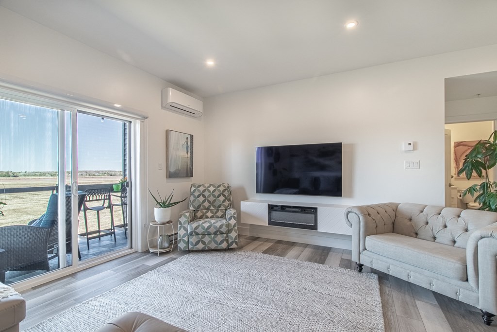 a living room with a couch and a tv and a balcony