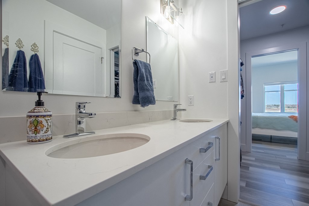 a white bathroom with two sinks and a mirror