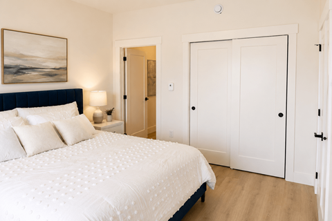 A bedroom with a large bed and a painting on the wall.