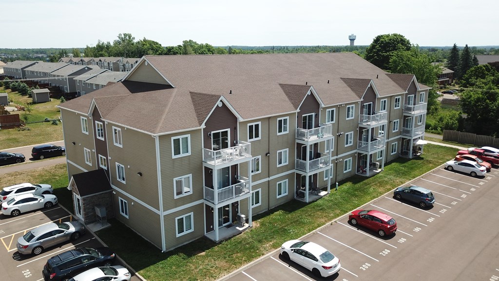 an aerial view of an apartment building with balconies and a parking lot