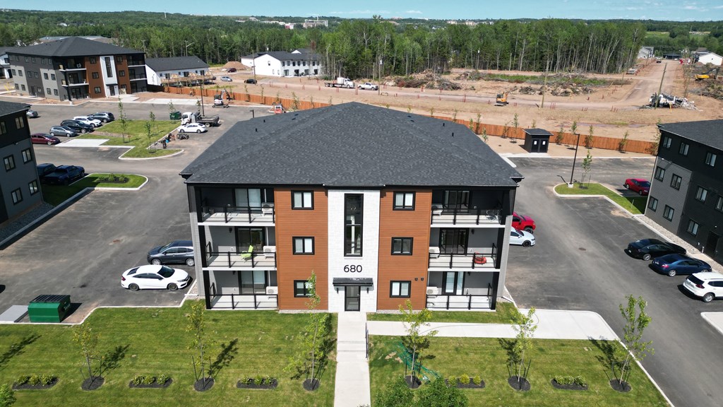 an aerial view of an apartment building with a parking lot