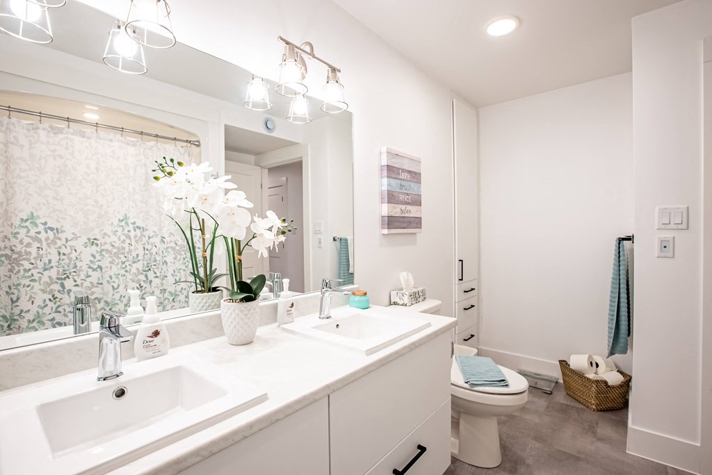a white bathroom with two sinks and a toilet