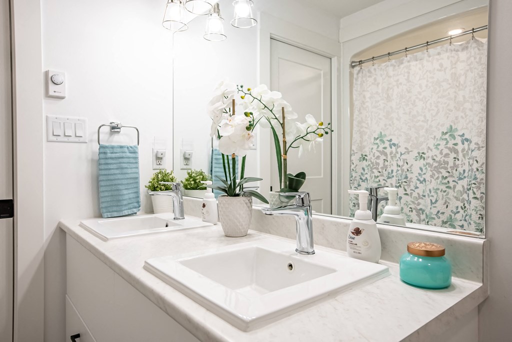 a white bathroom with two sinks and a mirror
