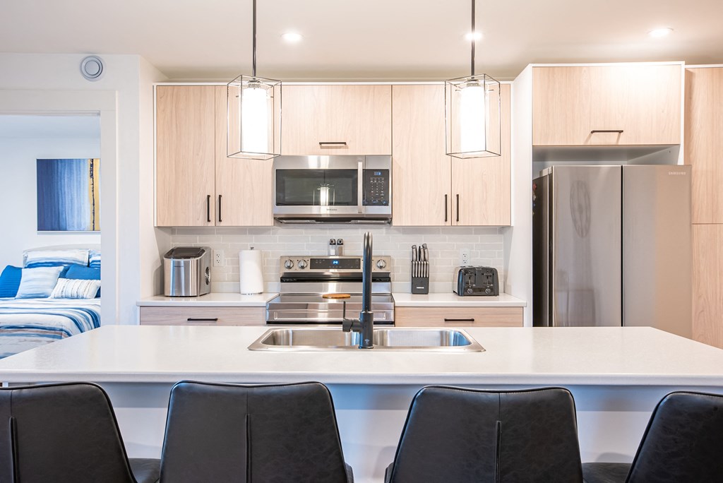 a kitchen with a white counter top and a sink