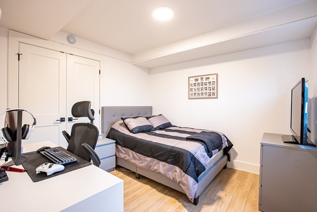 a bedroom with a bed and a desk and a tv