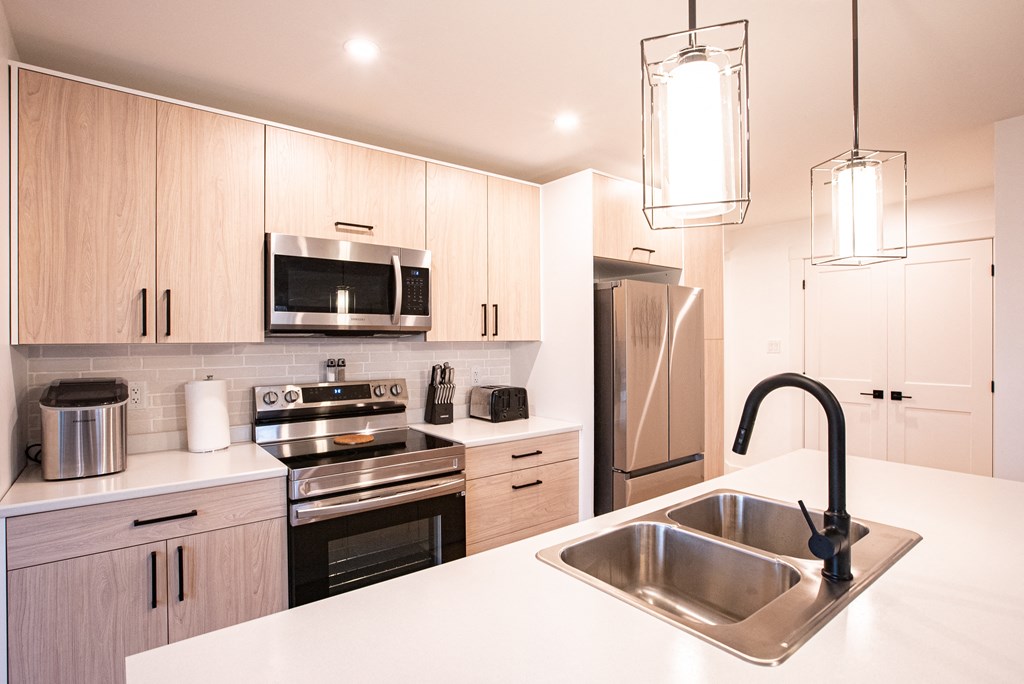 a kitchen with white counter tops and a sink