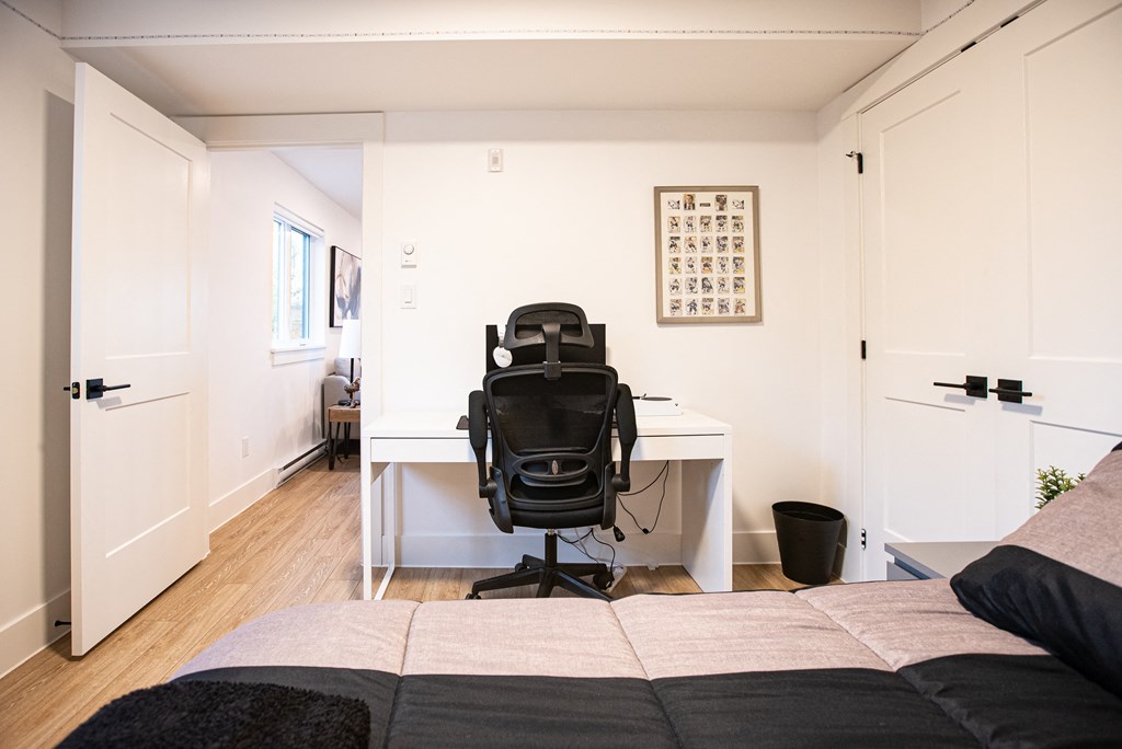 a bedroom with a bed and a desk with a chair