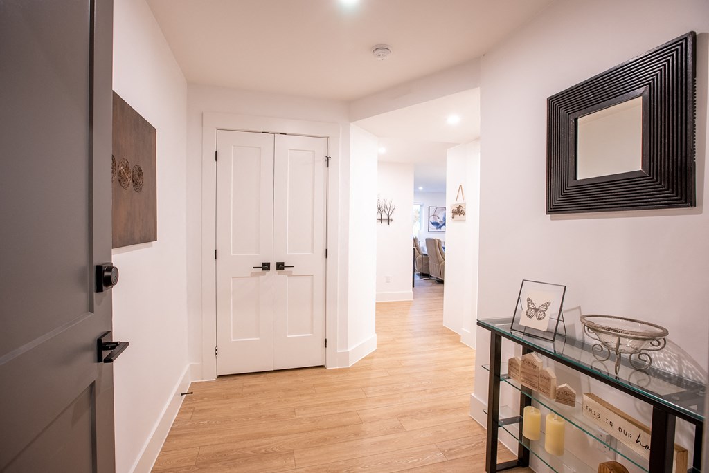 a hallway with a white door and a glass table