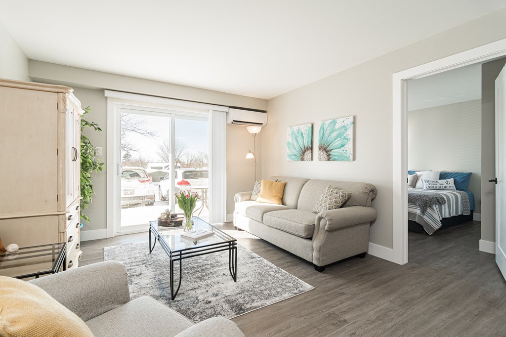 a living room with a couch and a coffee table    and a window