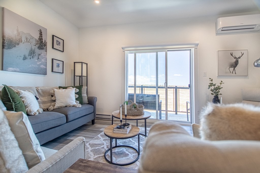 a living room with couches and a sliding glass door to a balcony