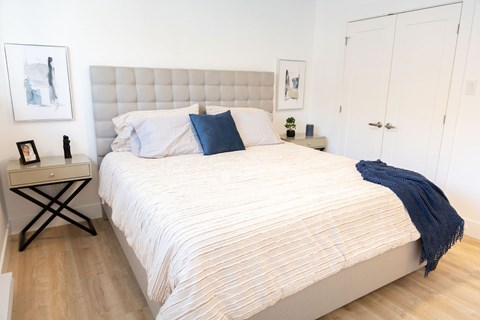 A bed with a white comforter and a blue pillow is in the image.