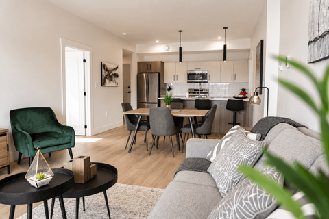 A modern living room with a green armchair and a grey sofa.