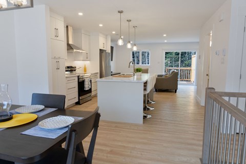 A modern kitchen with a dining table set for two.