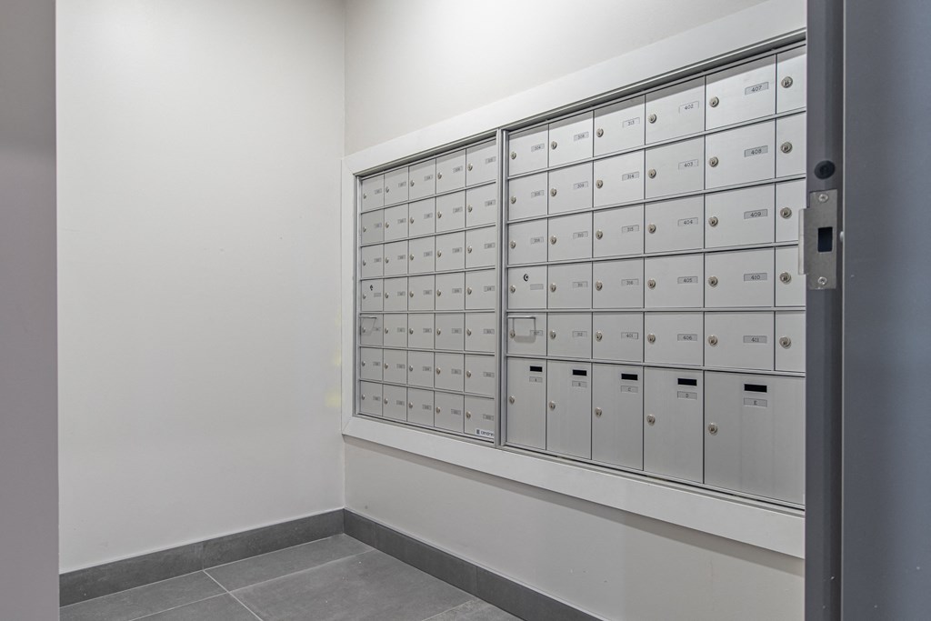 a wall of lockers in a room with white walls and flooring