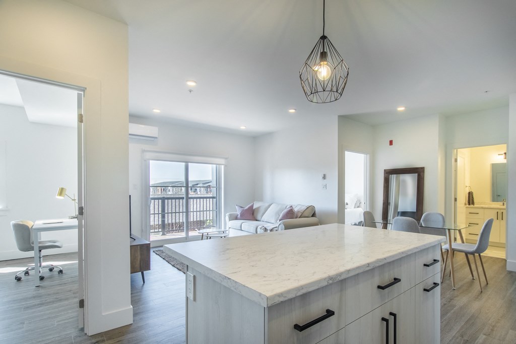 a kitchen island with a view of a living room and a dining room