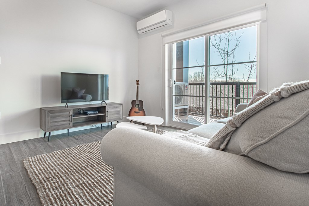 a living room with a couch and a tv and a window