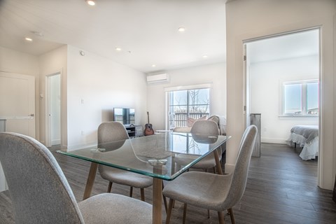 a dining room with a glass table and chairs
