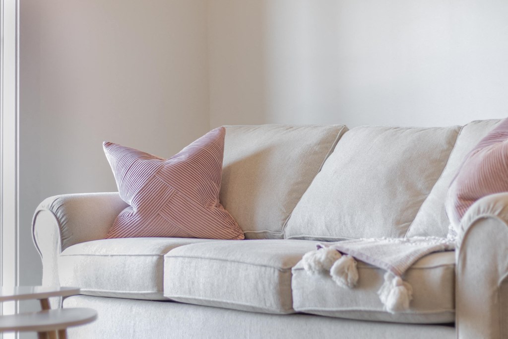 a couch with two pillows on it in a living room