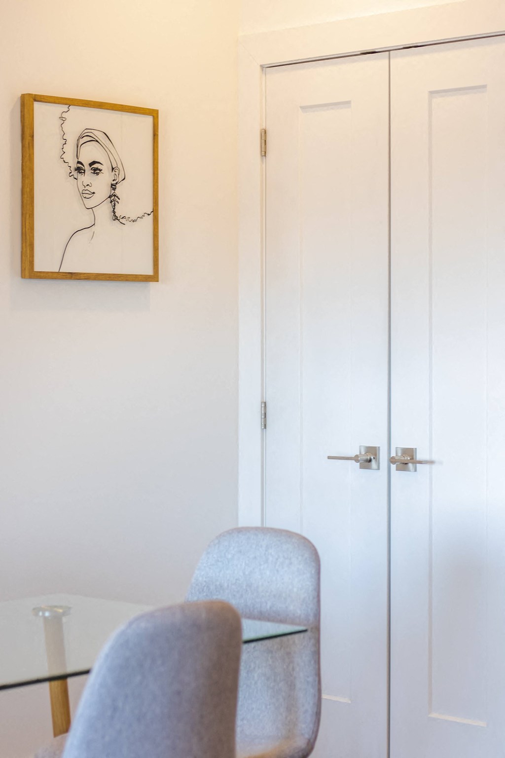 a dining room table with two chairs and a drawing of a woman on the wall
