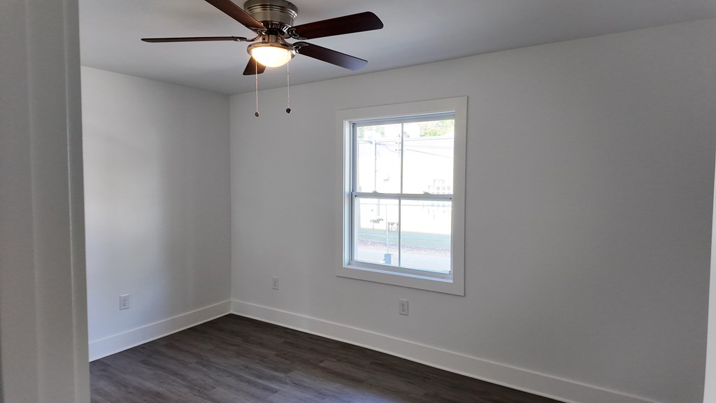 A room with a ceiling fan and a window.