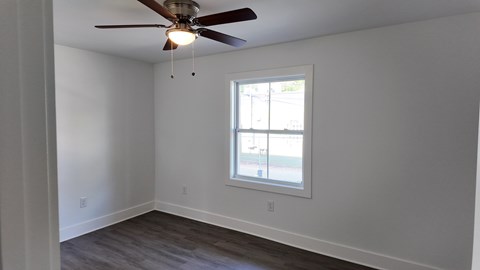 A room with a ceiling fan and a window.