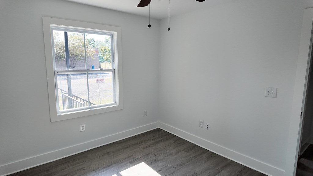 A room with a window and a ceiling fan.