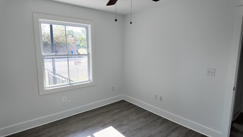 A room with a window and a ceiling fan.