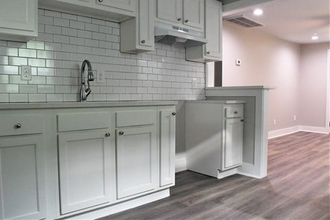 a view of a kitchen with white cabinets and white subway tile