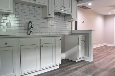 a view of a kitchen with white cabinets and a sink