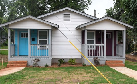 A white house with a blue door and a red door.