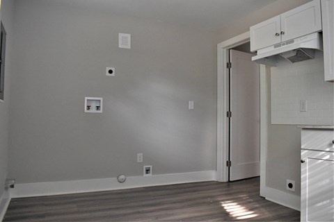 A kitchen with a white cabinet and a doorway leading to another room.