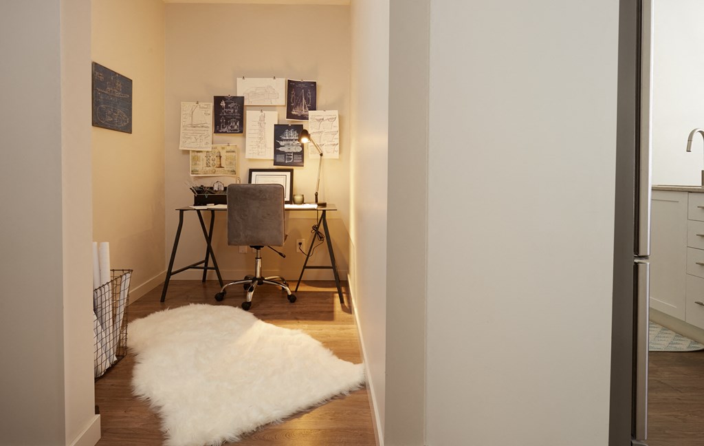 a bedroom with a desk with a chair and a white rug