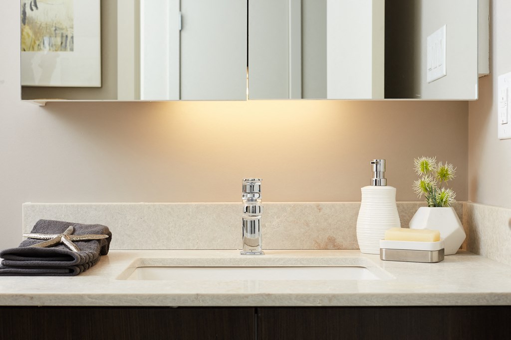 a kitchen counter with a sink and a mirror