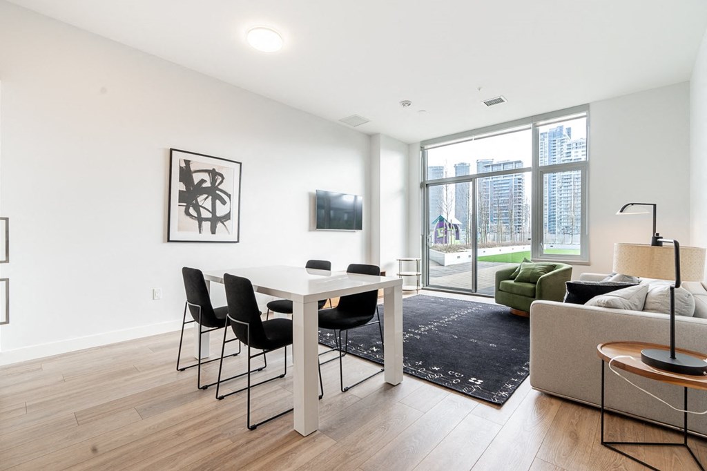 a living room with a table and chairs and a large window