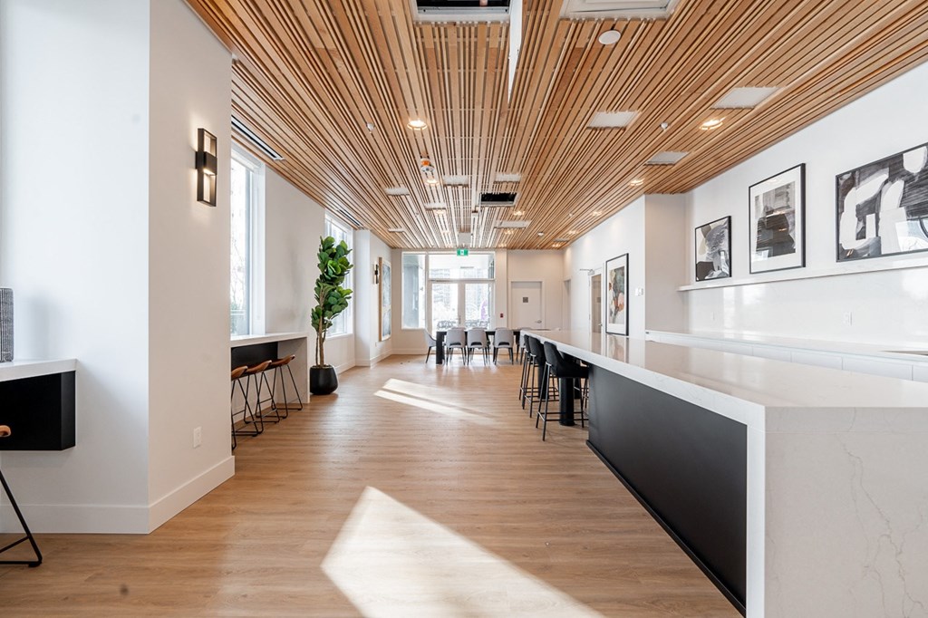 a large room with a long counter and chairs in it