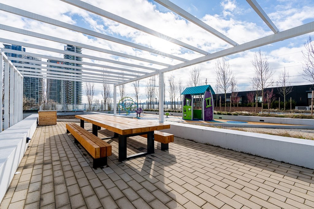 a picnic table and benches under a glass canopy on a patio