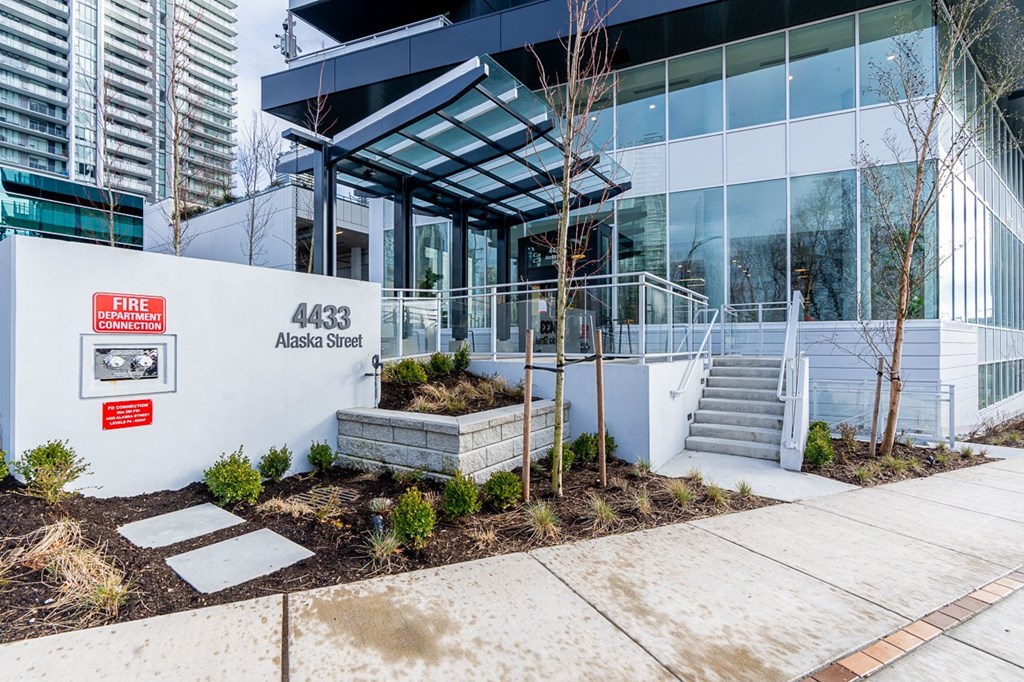 the front of a building with a staircase and a glass facade