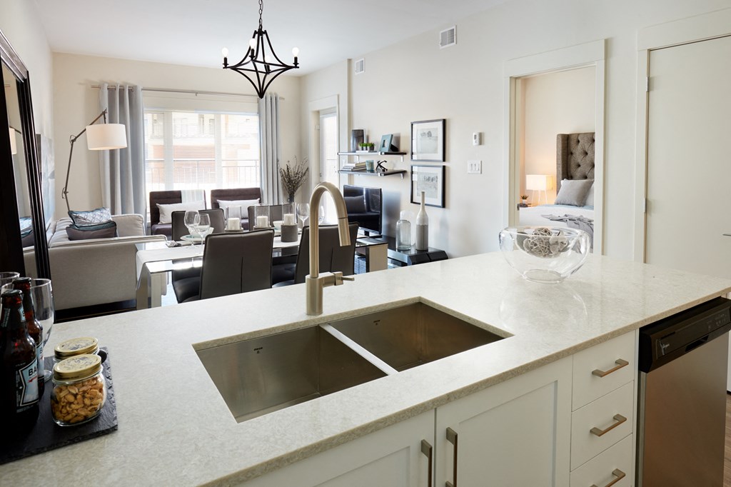 a kitchen counter with a sink and a view of a living room