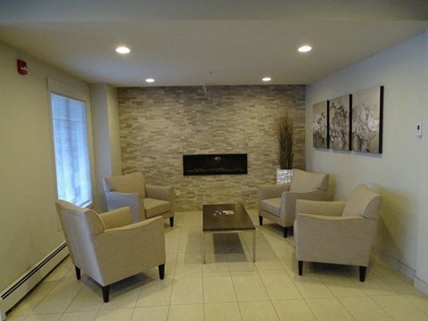 a living room with chairs and a fireplace