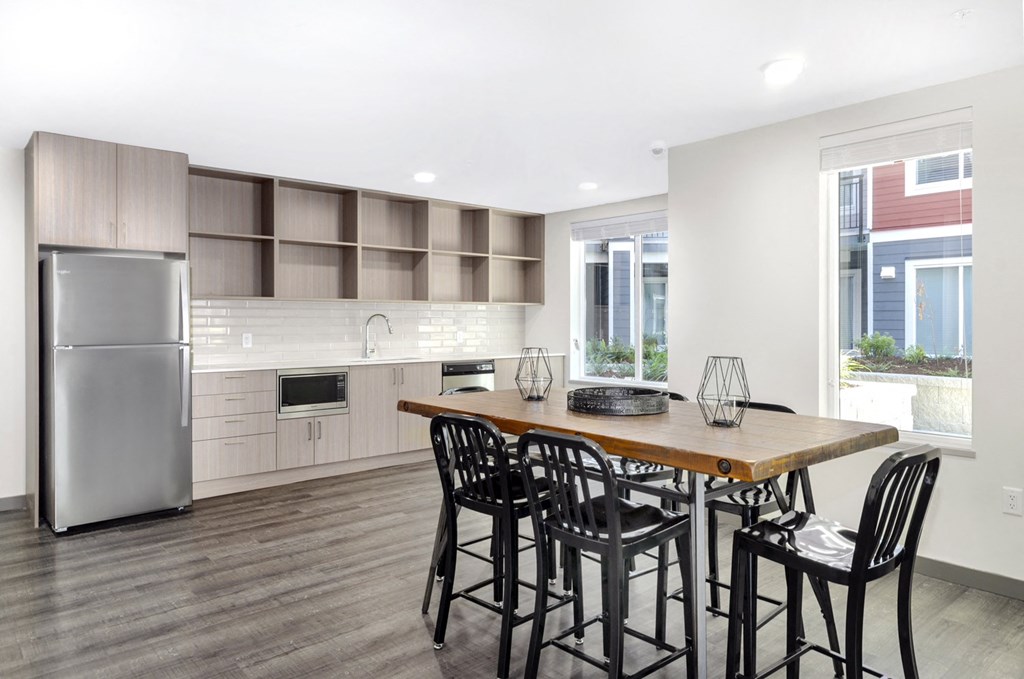 a kitchen with a table and chairs and a refrigerator