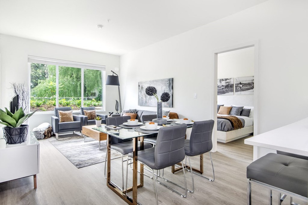 a living room with a table and chairs and a bedroom