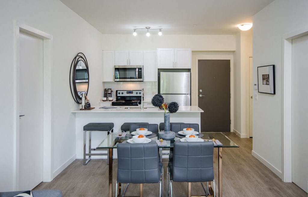 a dining room and kitchen area with a table and chairs