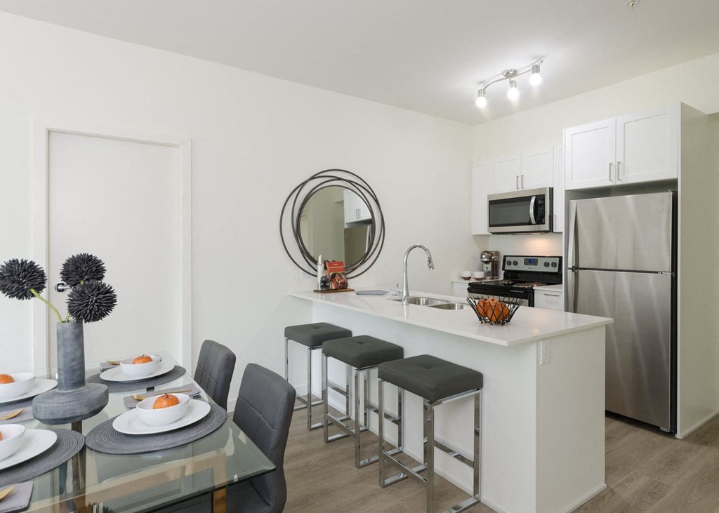 a kitchen and dining area with a stainless steel refrigerator