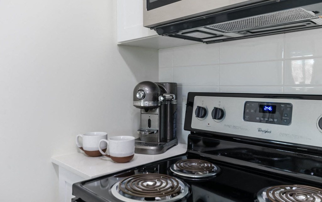 a small kitchen with a stove and a coffee maker