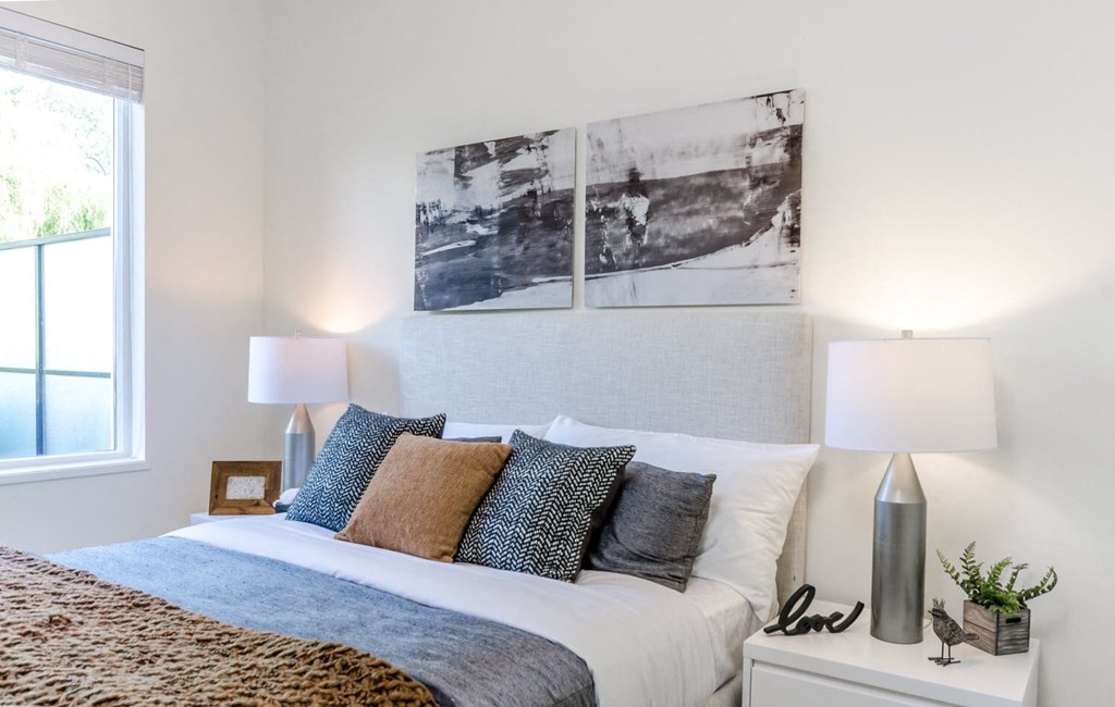 a bedroom with a bed and three pictures on the wall