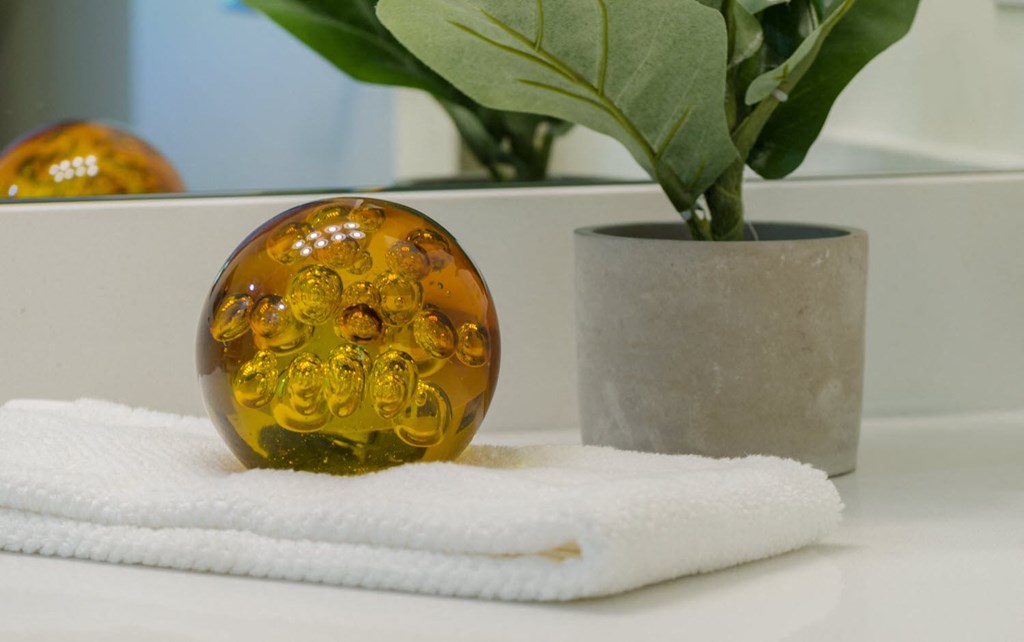 a glass egg sitting on a towel next to a potted plant